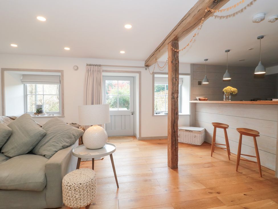 A living room with a sofa and lamp at The Threshing Barn in Chipping Norton
