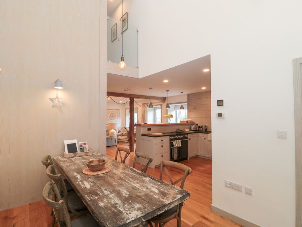 A dining room with a wooden table and chairs at The Threshing Barn in Chipping Norton