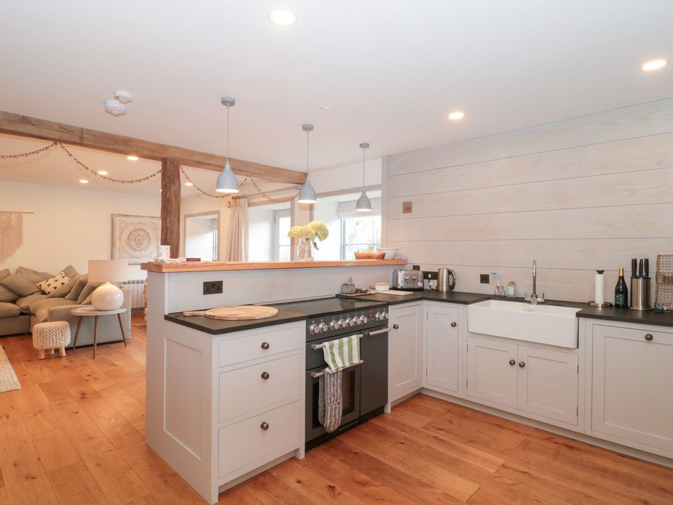 A kitchen with a stove and sink at The Threshing Barn Chipping Norton