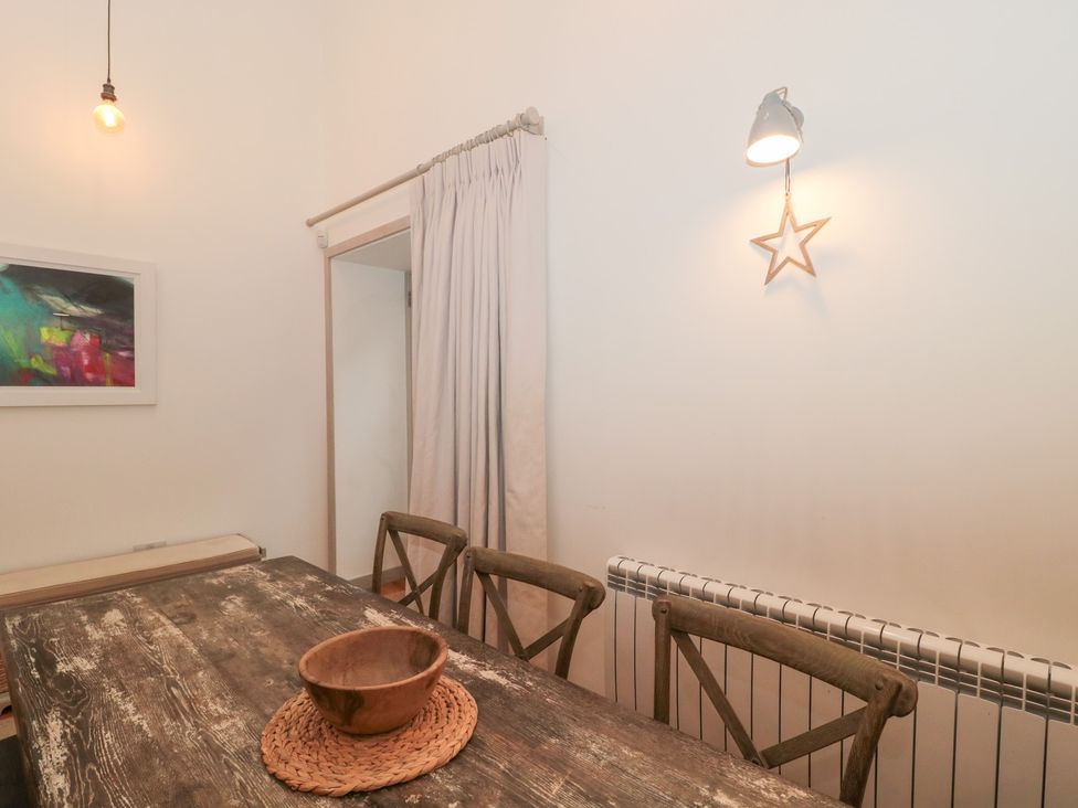 A dining room with a wooden table and a bowl at The Threshing Barn in Chipping Norton