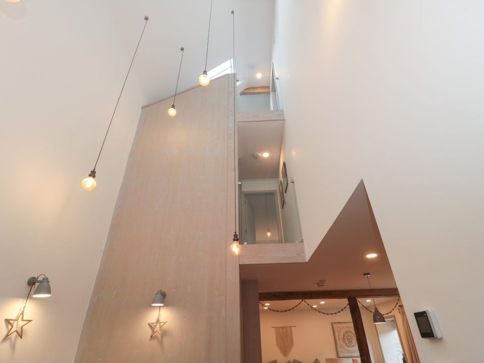 An indoor view with stairs and hanging lights at The Threshing Barn in Chipping Norton