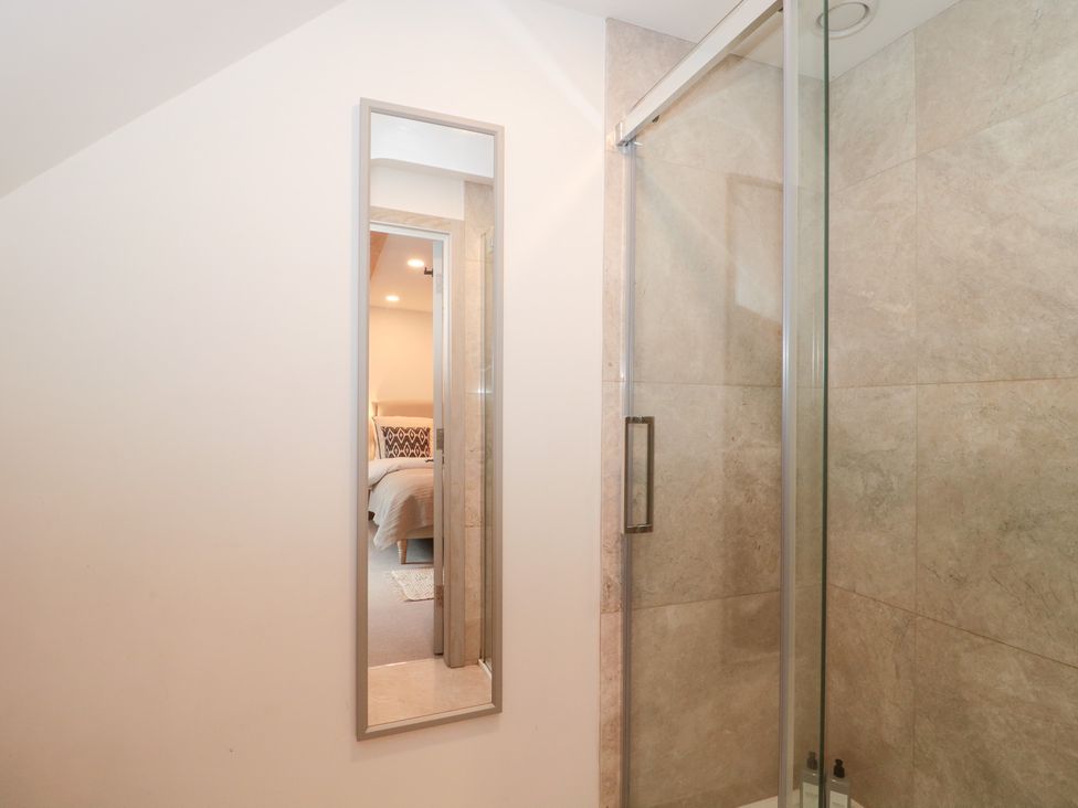A bathroom with a mirror and a shower at The Threshing Barn in Chipping Norton