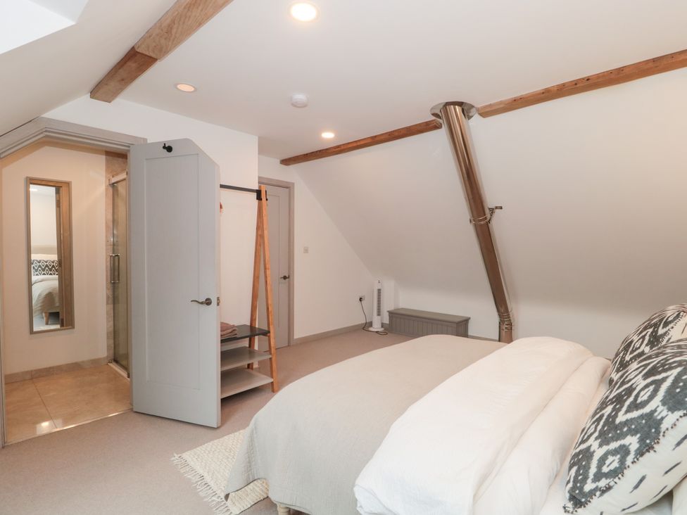 A bedroom with bed and shelves at The Threshing Barn, Chipping Norton