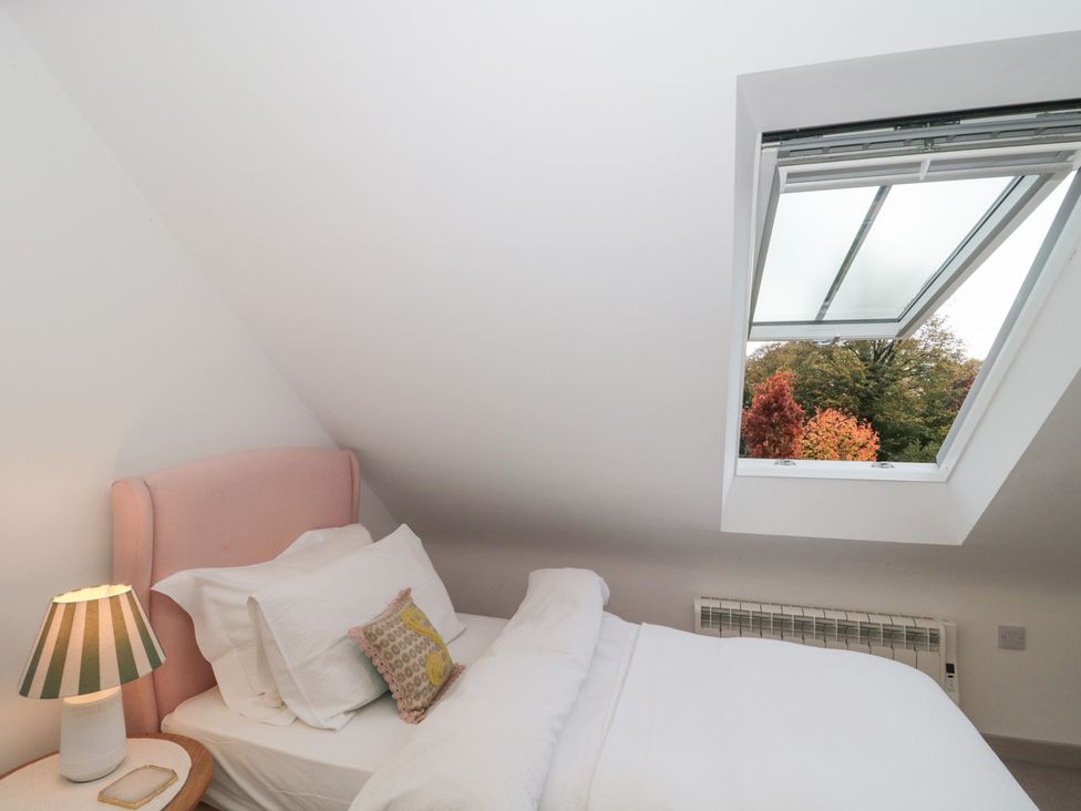 A bedroom with a bed and lamp at The Threshing Barn Chipping Norton