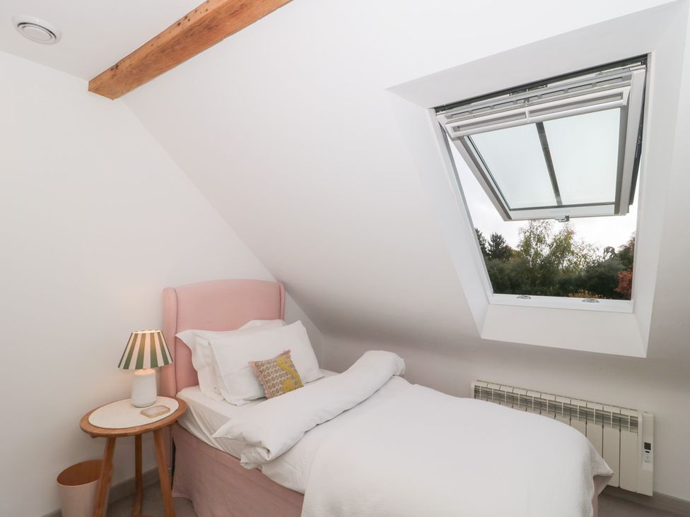 A bedroom with a bed and a window at The Threshing Barn Chipping Norton