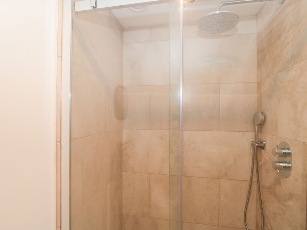 A shower with glass door and chrome fixtures at The Threshing Barn Chipping Norton
