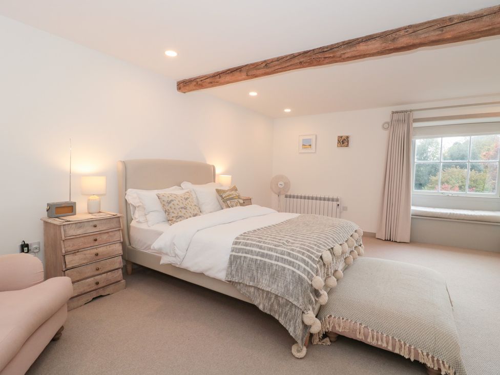 A bedroom with a bed and side table at The Threshing Barn Chipping Norton
