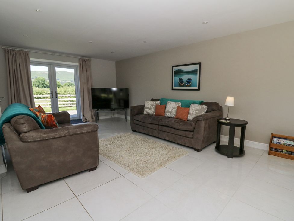 A living room with a sofa and TV at Little Penrhosgoch Barn in Llandrindod Wells