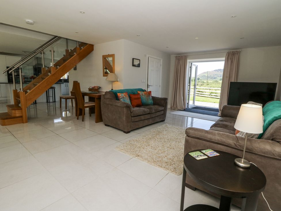 A living room with sofas and a dining table at Little Penrhosgoch Barn Llandrindod Wells