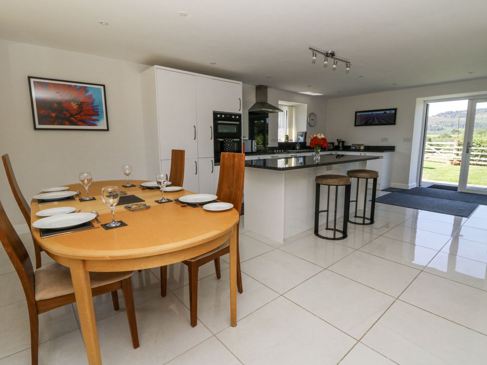 A kitchen with a dining area and island at Little Penrhosgoch Barn Llandrindod Wells