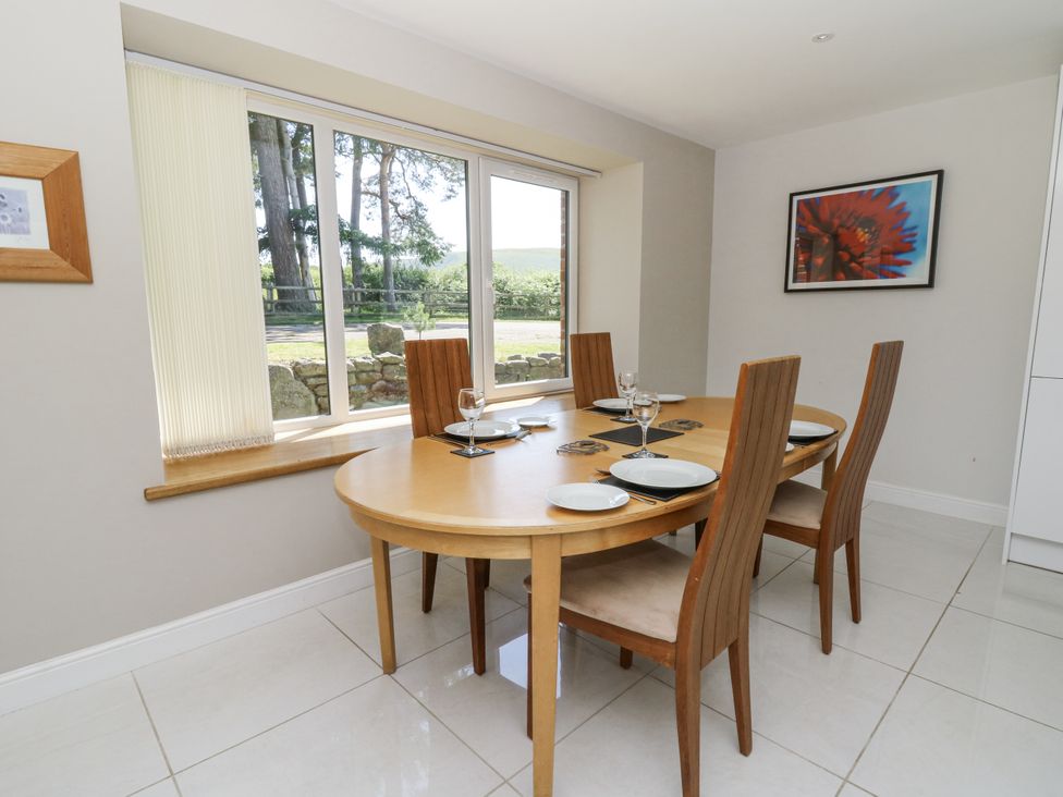 A dining room with a wooden table and chairs at Little Penrhosgoch Barn Llandrindod Wells
