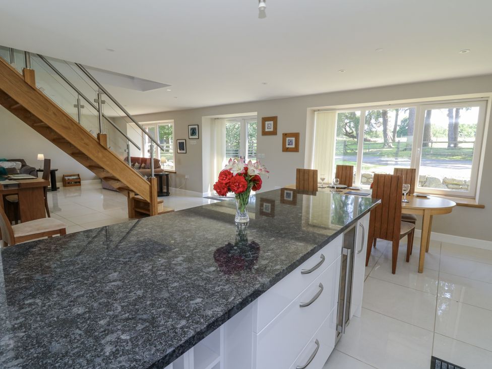 A kitchen with an island and dining table at Little Penrhosgoch Barn in Llandrindod Wells