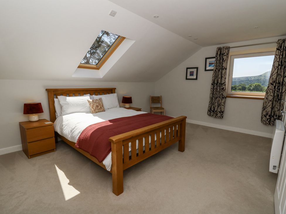 A bedroom with a bed and nightstands at Little Penrhosgoch Barn in Llandrindod Wells