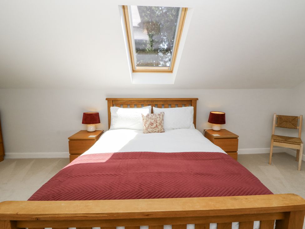 A bedroom with a bed and nightstands at Little Penrhosgoch Barn in Llandrindod Wells