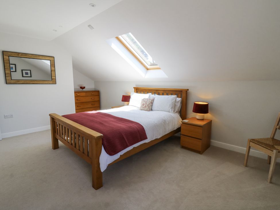 A bedroom with a bed and wooden furniture at Little Penrhosgoch Barn Llandrindod Wells