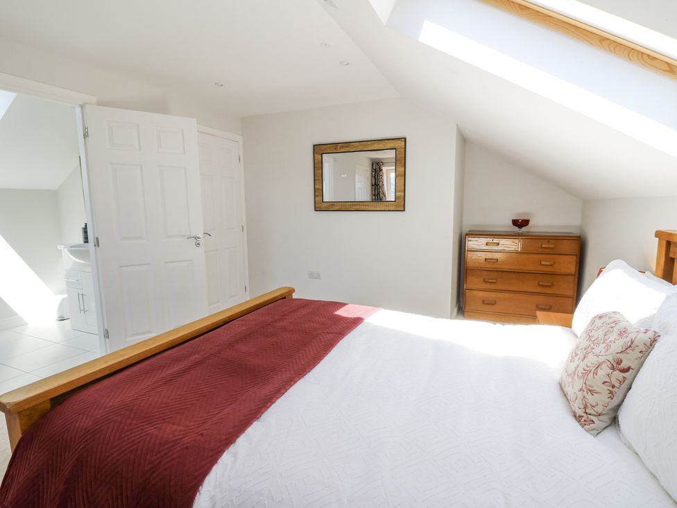 A bedroom with a bed and a dresser at Little Penrhosgoch Barn in Llandrindod Wells