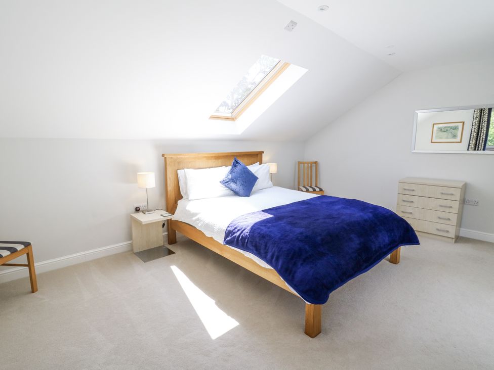 A bedroom with a bed and lamp at Little Penrhosgoch Barn in Llandrindod Wells