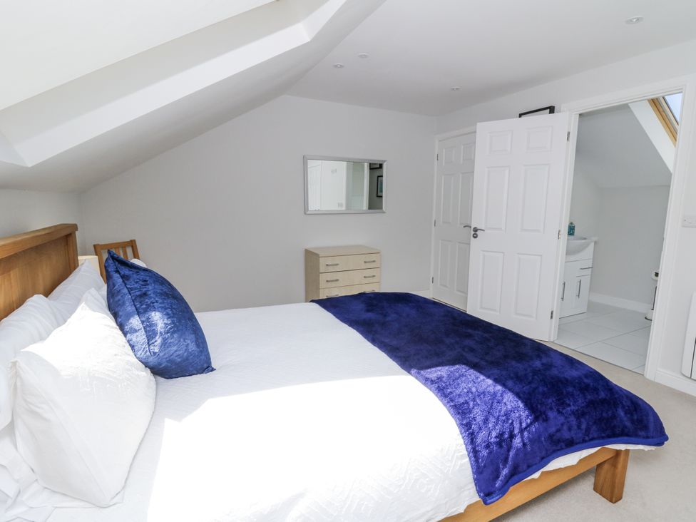 A bedroom with a bed and mirror at Little Penrhosgoch Barn in Llandrindod Wells