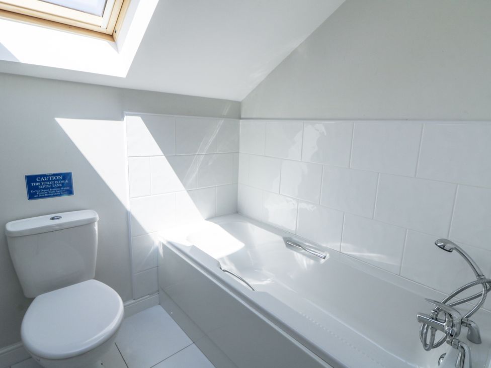 A bathroom with a bathtub and toilet at Little Penrhosgoch Barn in Llandrindod Wells