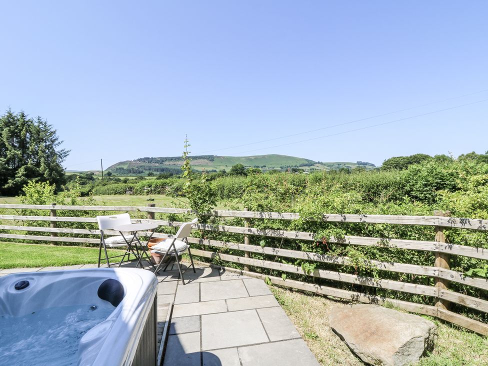An outdoor area with a hot tub and seating at Little Penrhosgoch Barn in Llandrindod Wells