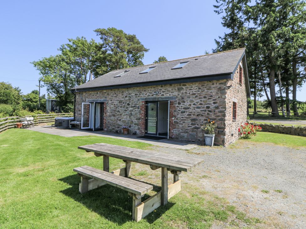 An outdoor area with a building, table and chairs at Little Penrhosgoch Barn in Llandrindod Wells
