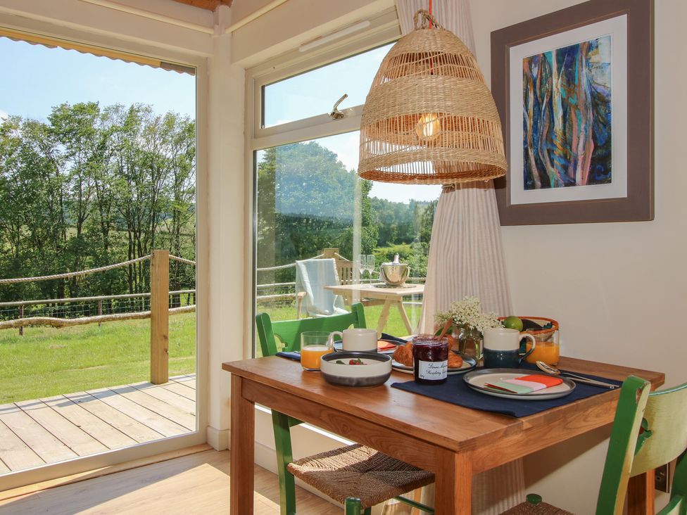 A dining room with a table set for breakfast at Owl's Hollow in Chapel Lawn near Clun