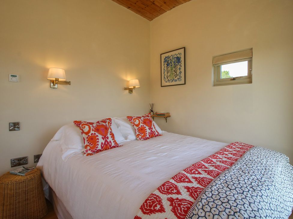A bedroom with a double bed and wall art at Owl's Hollow Chapel Lawn near Clun