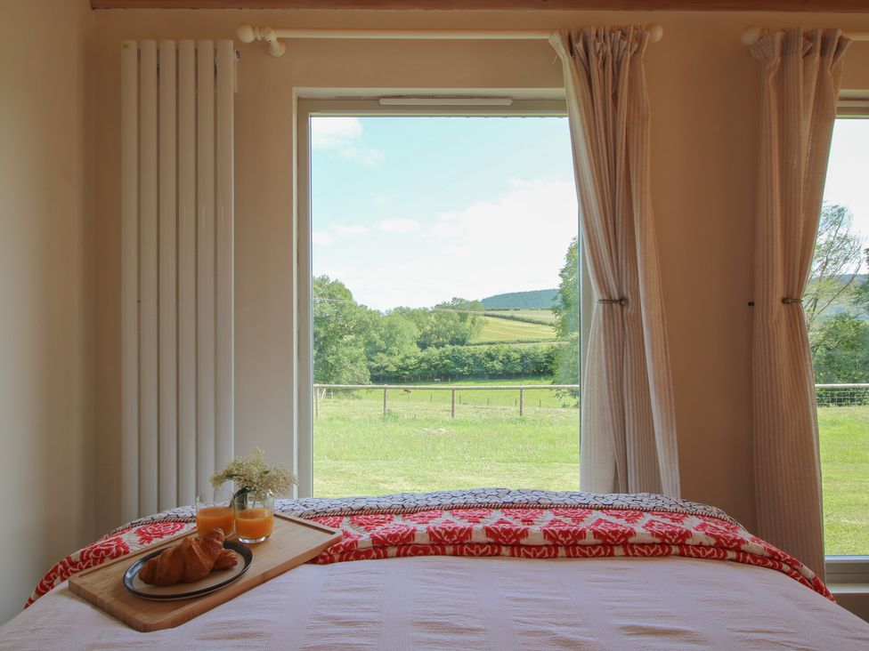 A bedroom with a bed and breakfast tray at Owl's Hollow Chapel Lawn near Clun