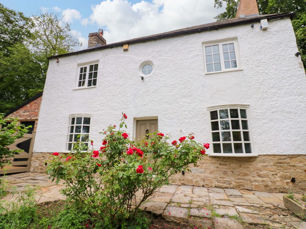 A house with white exterior and red flowers in front at White House in Durham