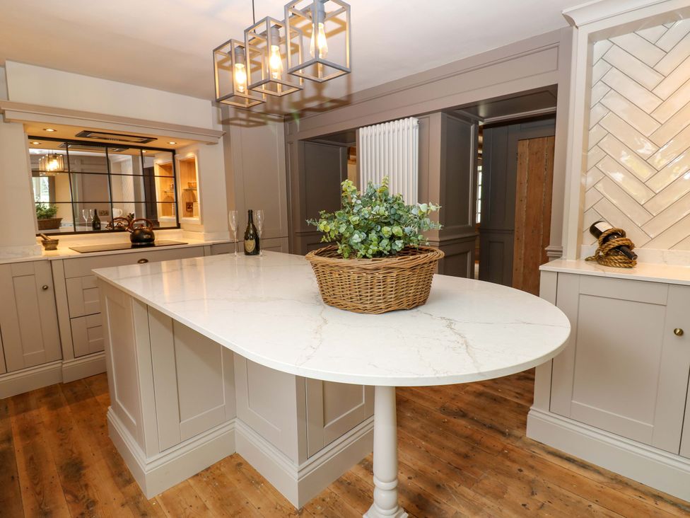 A kitchen with an island and a basket in the center at White House in Durham