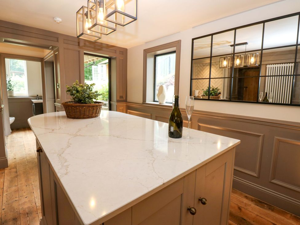 A kitchen with an island and bottle on it at White House in Durham