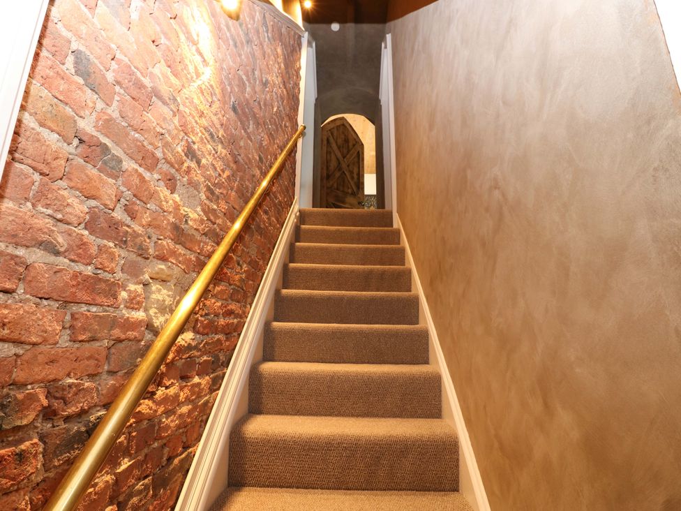 A staircase with a handrail leading to a door at White House in Durham