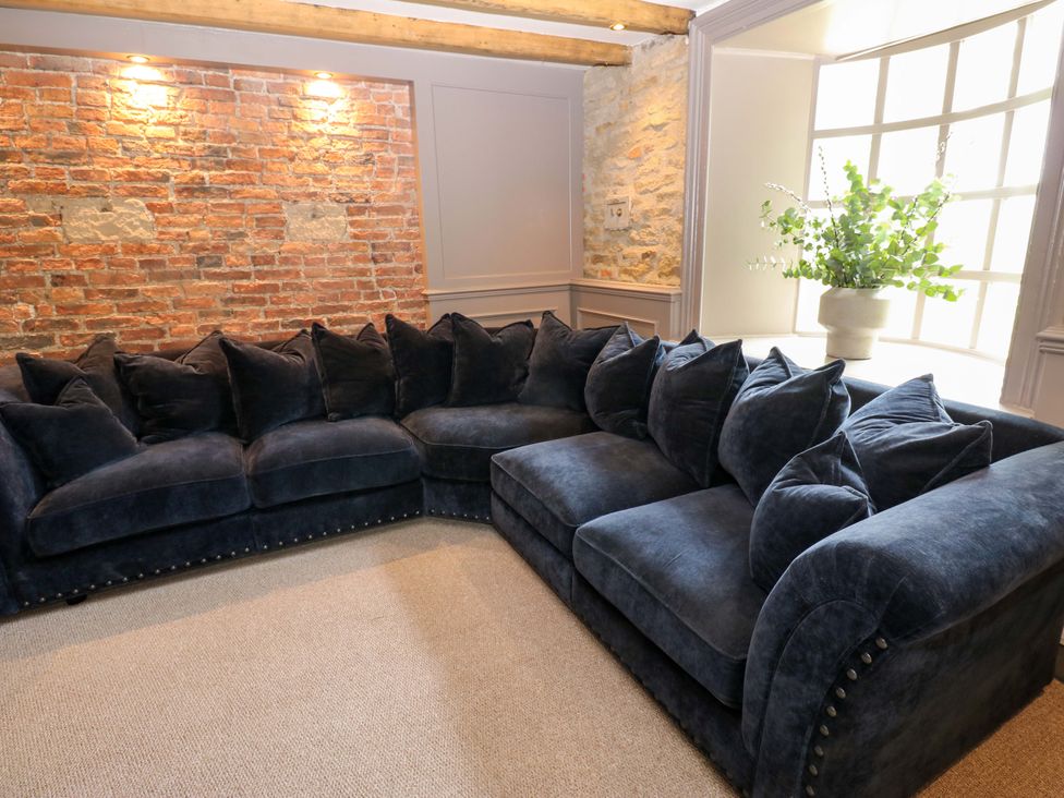 A living room with a large sofa against a brick wall at White House in Durham