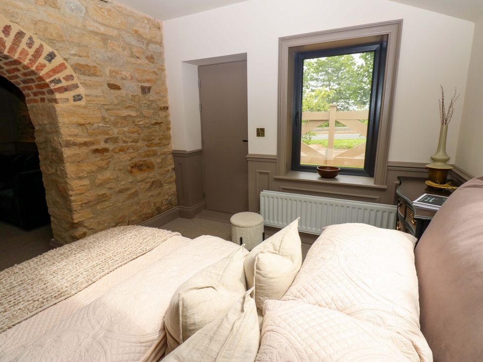 A bedroom with a bed and stone wall at White House in Durham