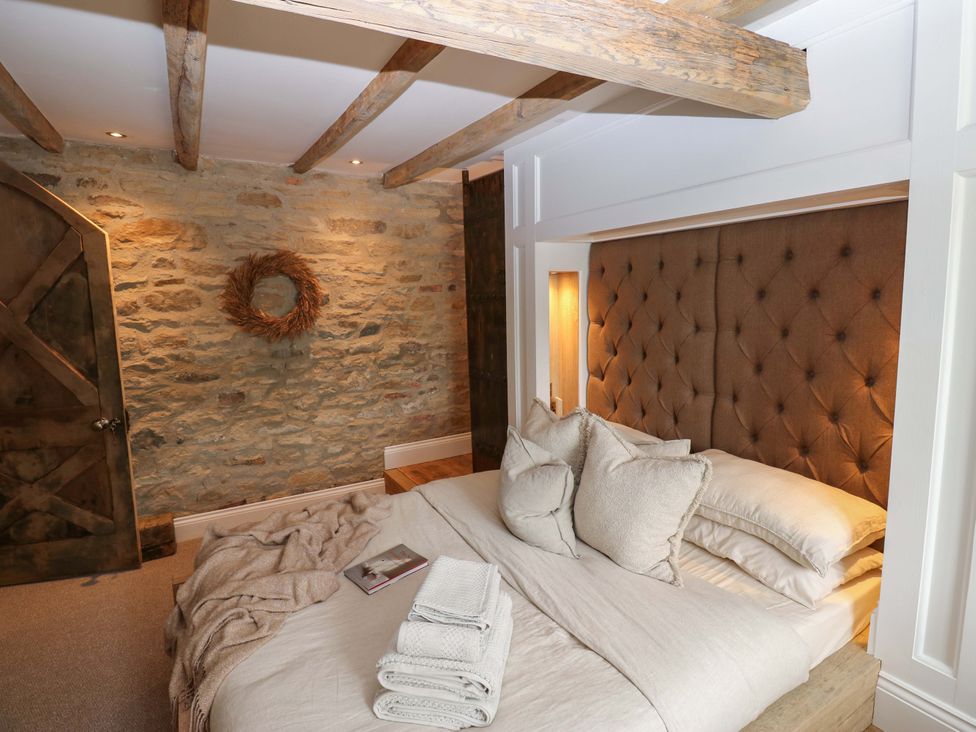 A bedroom with a bed and stone wall at White House in Durham