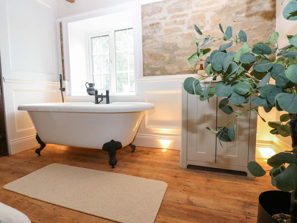 A bathroom with a bathtub and window at White House in Durham