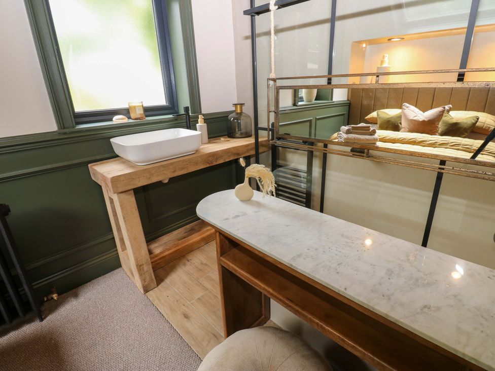 A bathroom with a washbasin and wooden table at White House in Durham