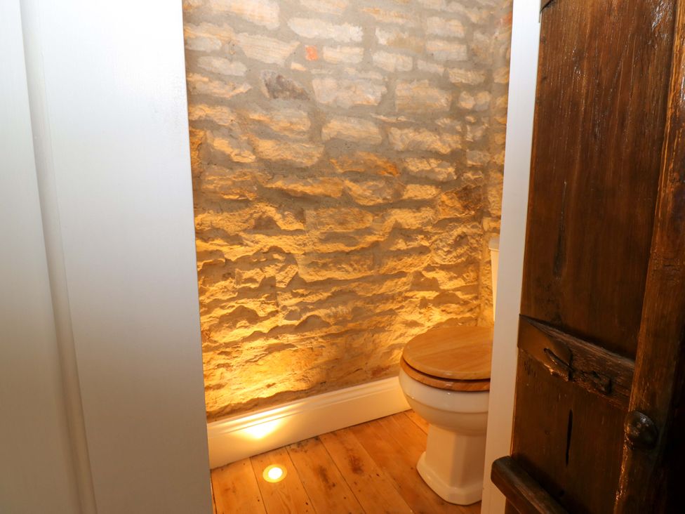 A bathroom with a toilet and stone walls at White House in Durham