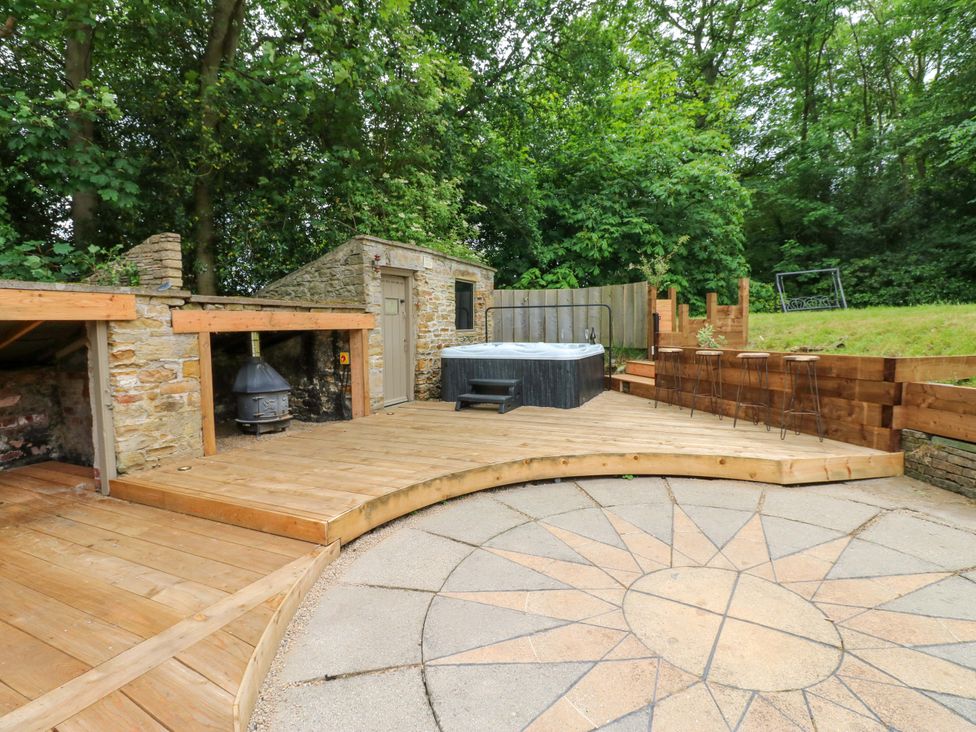 An outdoor area with a hot tub and wooden deck at White House in Durham
