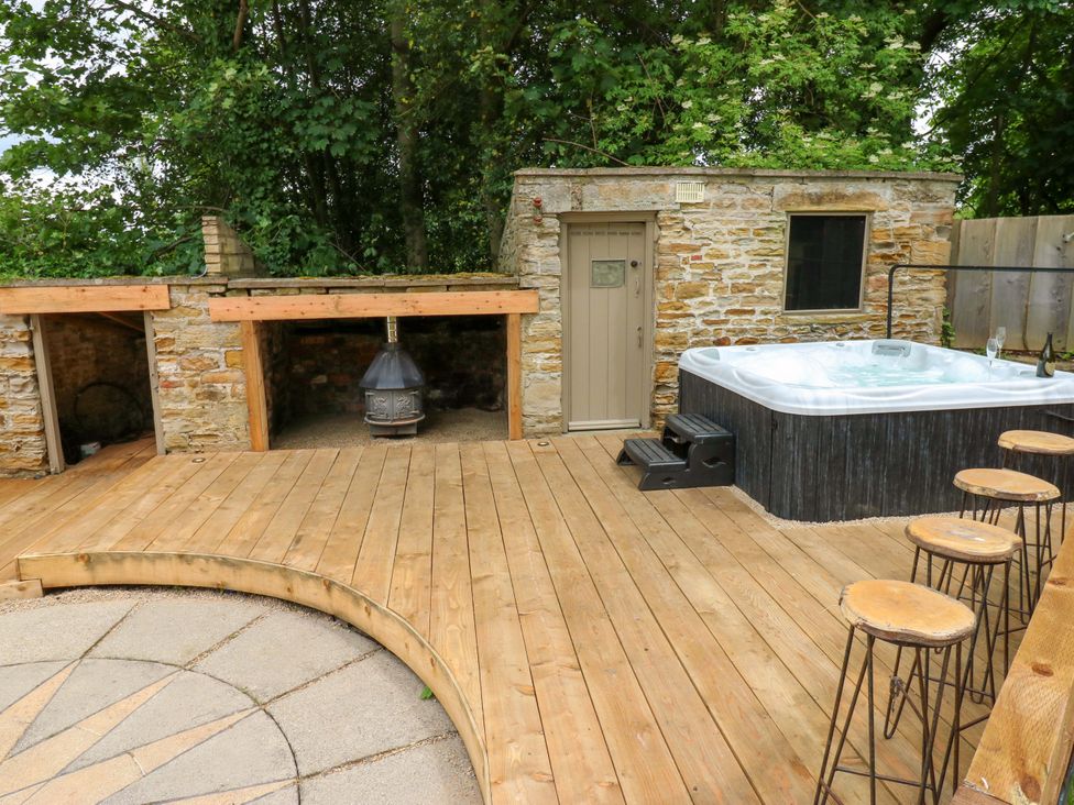 An outdoor area with a hot tub and seating at White House in Durham