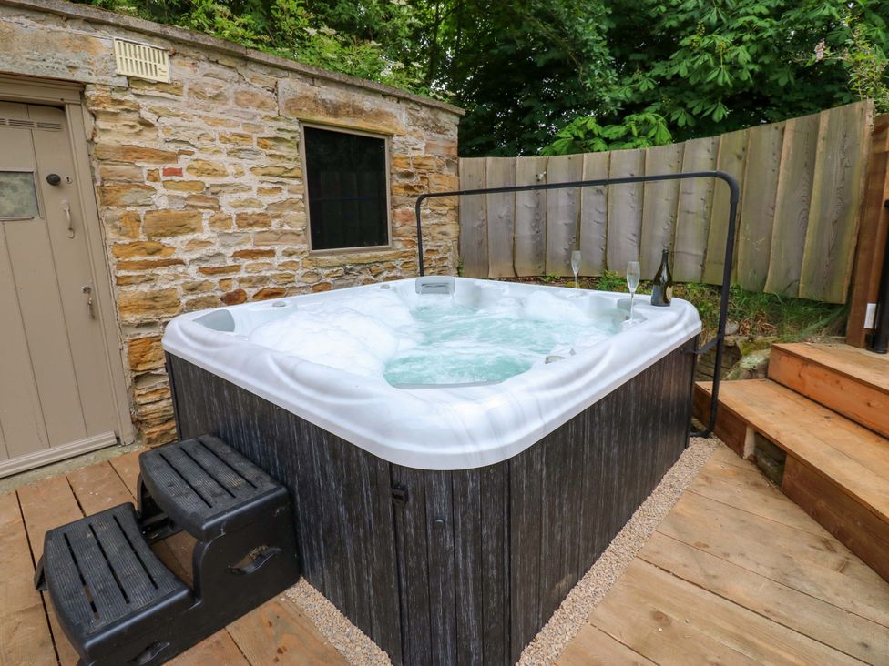 A hot tub with steps and a stone wall at White House in Durham