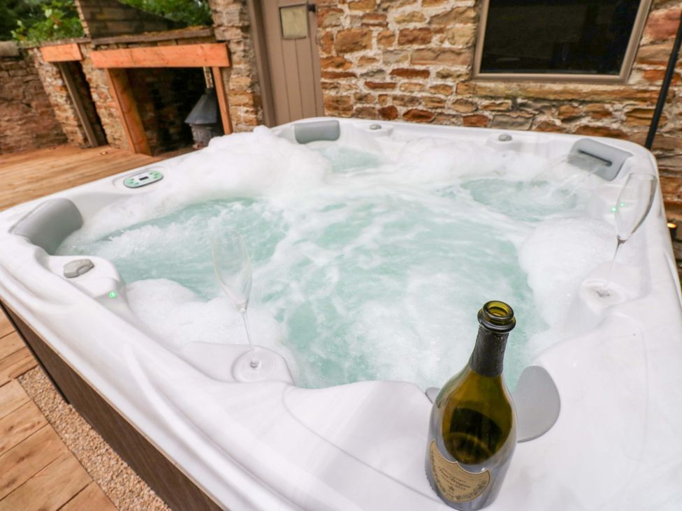 A hot tub with champagne on a wooden deck at White House in Durham