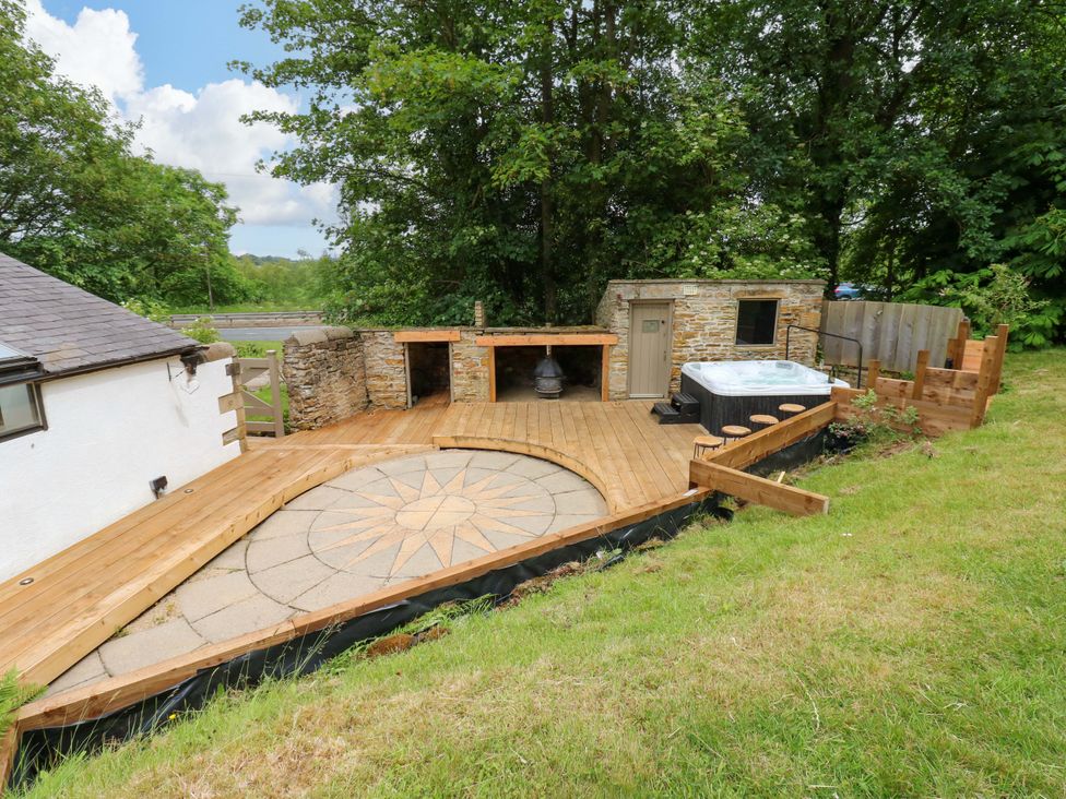 An outdoor space with a wooden deck and hot tub at White House, Durham