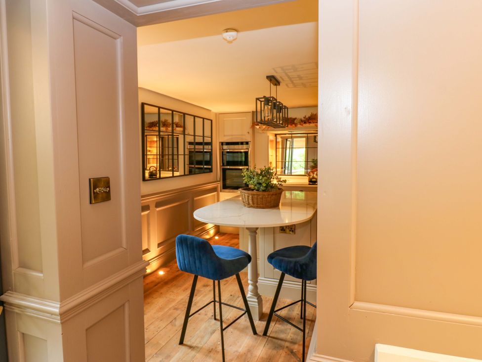 A kitchen with an island and stools at White House in Durham