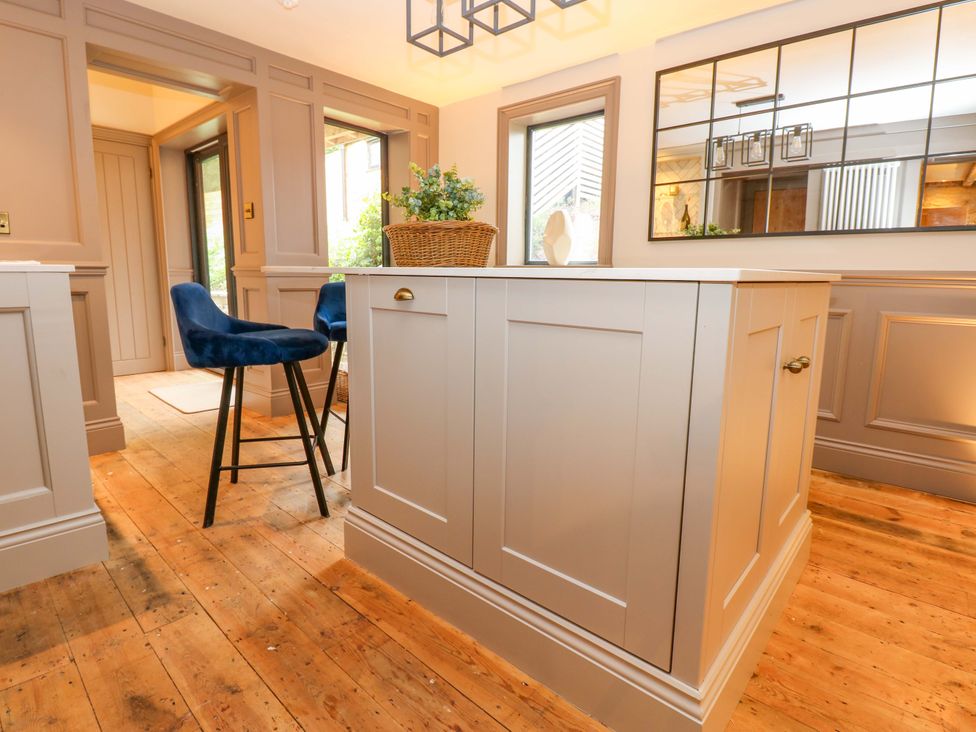 A kitchen with a bar stool and an island at White House in Durham
