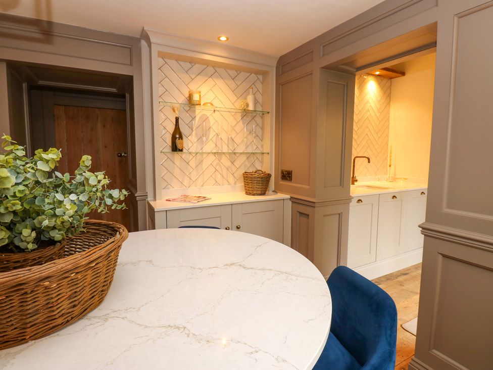 A kitchen with a table, chairs, and shelves at the White House in Durham