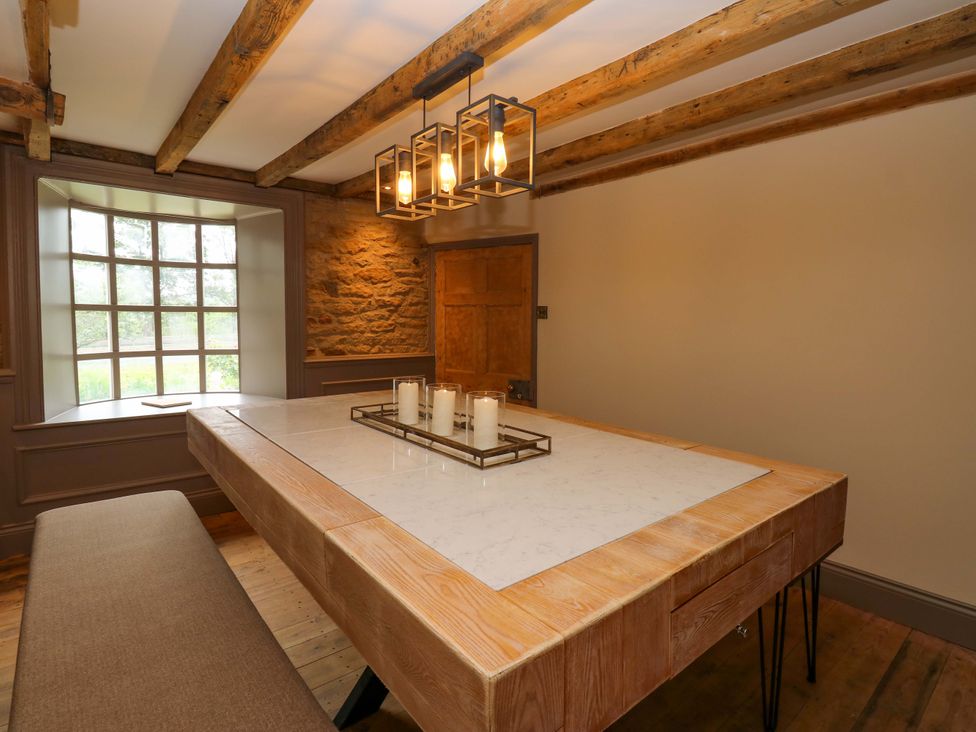 A dining room with a wooden table and candles at White House in Durham