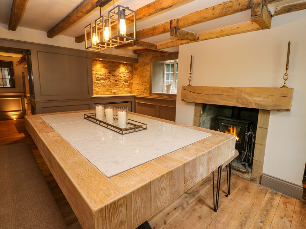 A dining room with a table and fireplace at White House in Durham