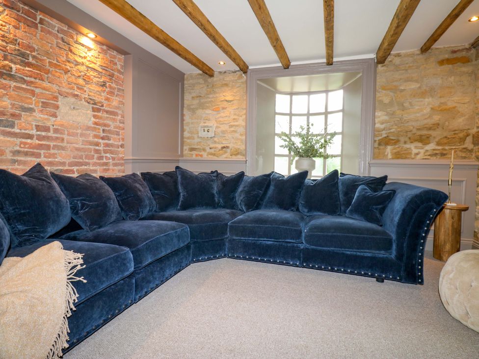 A living room with a sectional sofa and a window at White House in Durham