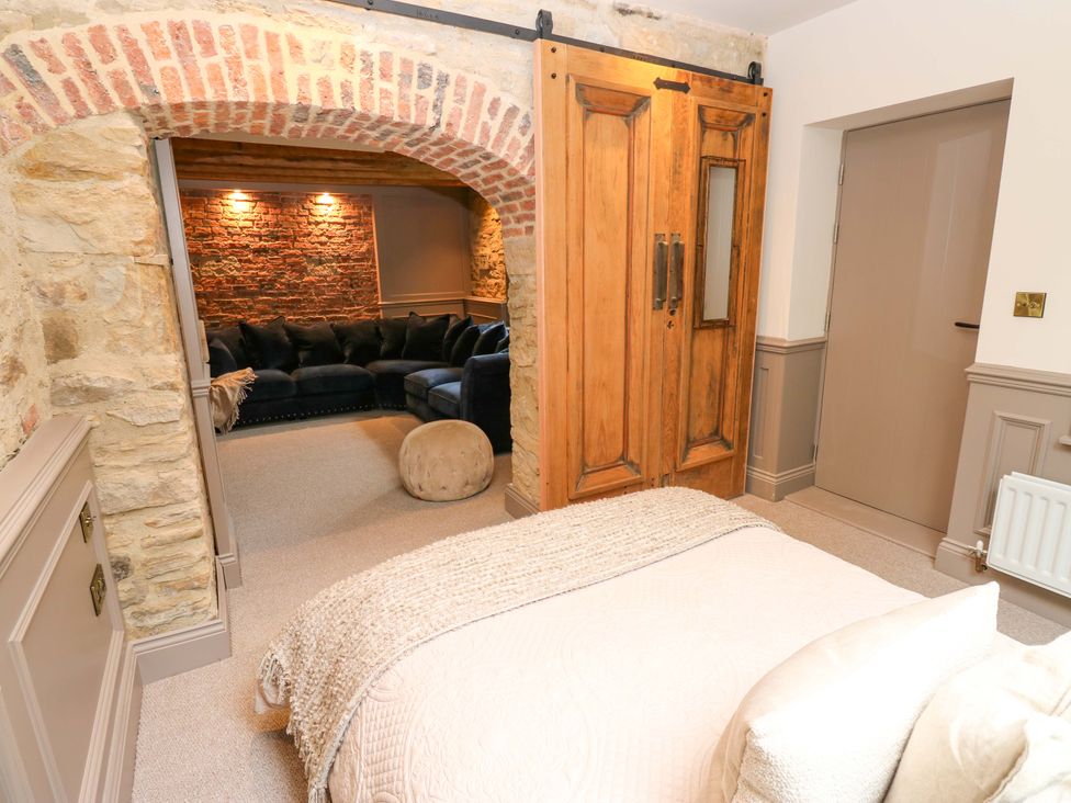 A bedroom with a bed and wardrobe leading to a living area at White House in Durham